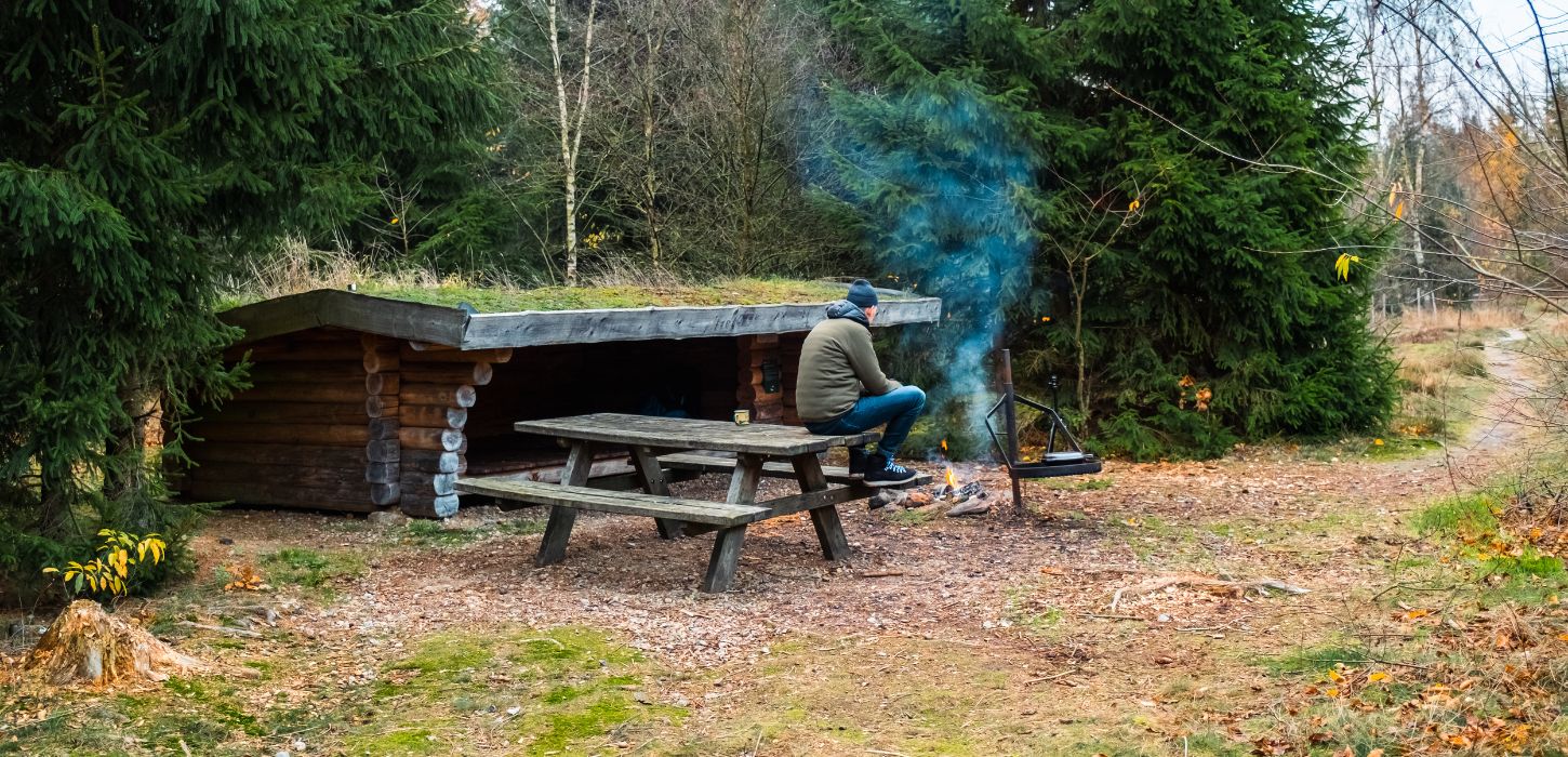 En person er på sheltertur i Frederikshåb Plantage og laver bål