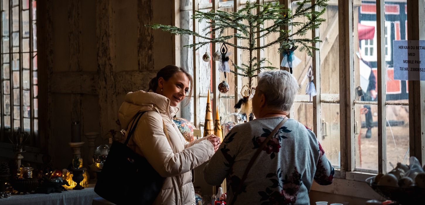 To personer kigger på boder til julemarkedet på Tirsbæk Gods