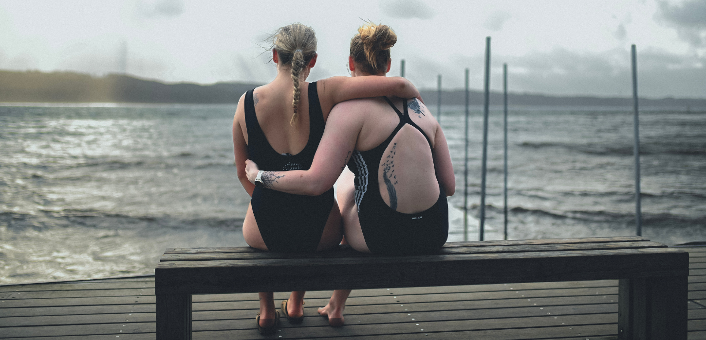 Zwei Frauen auf einer Bank gehen im Winter am Strand von Tirsbæk schwimmen