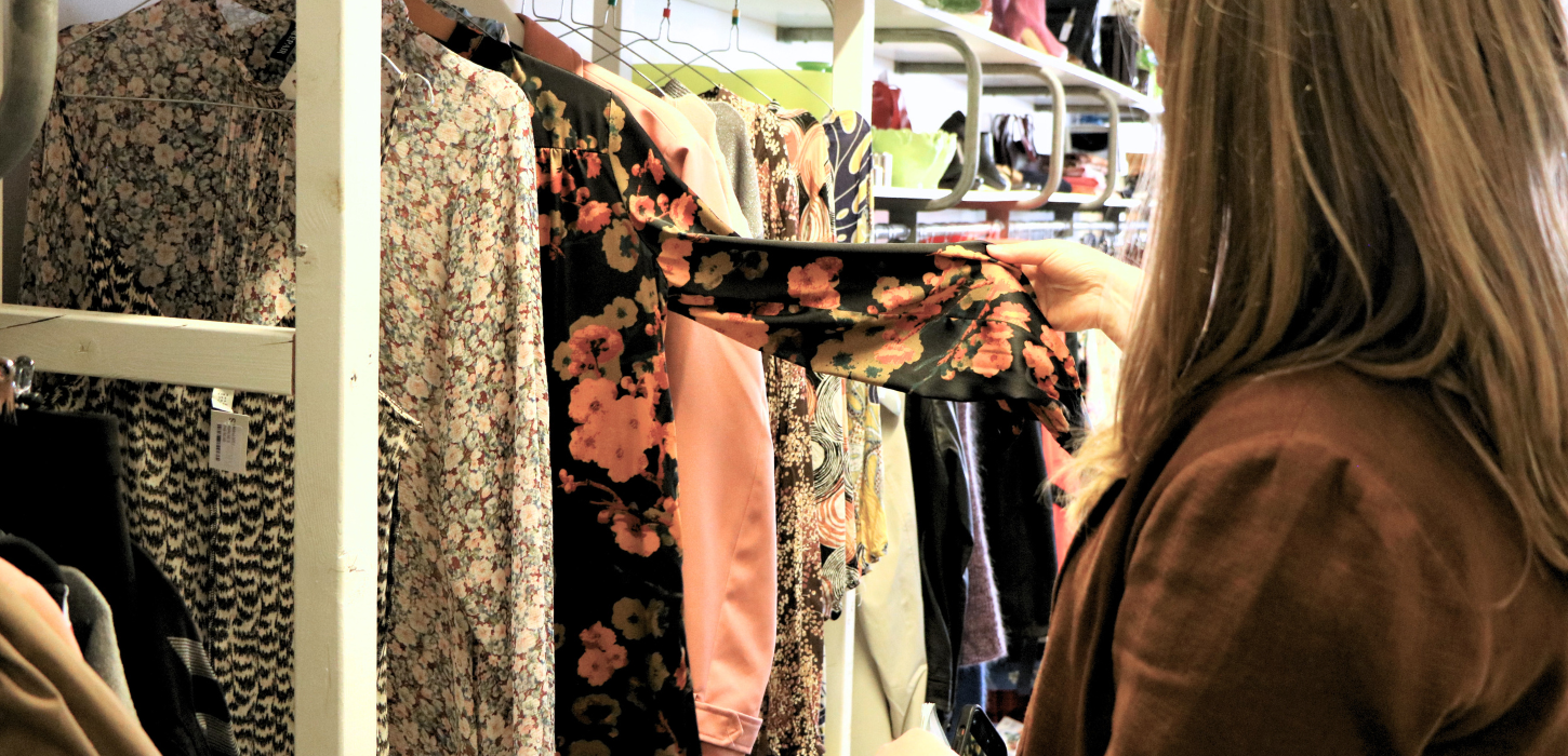 A person looks at clothes in a thrift shop in Give