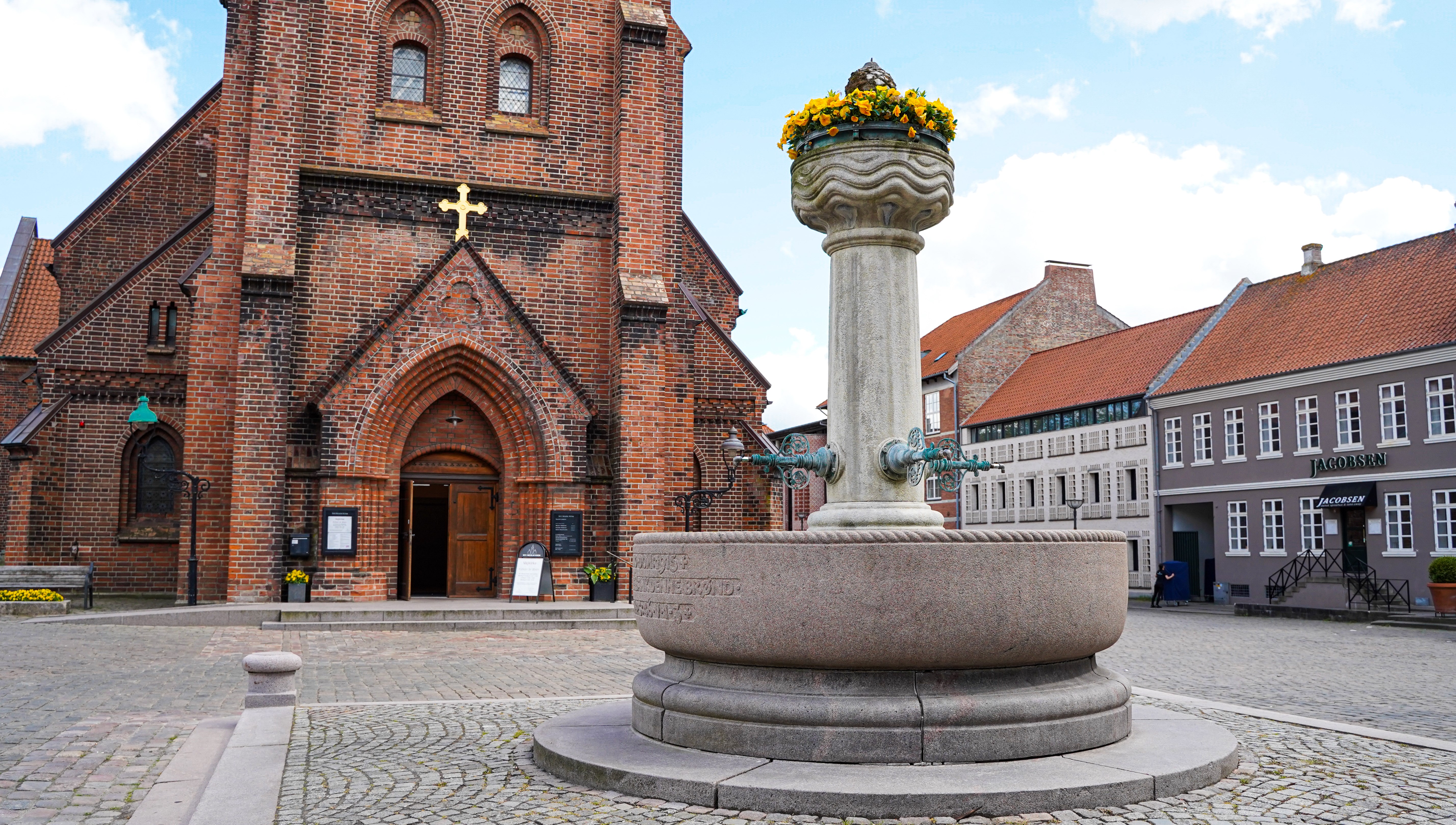 Ude foran Sct. Nicolai Kirke i Vejle med springvand i forgrunden