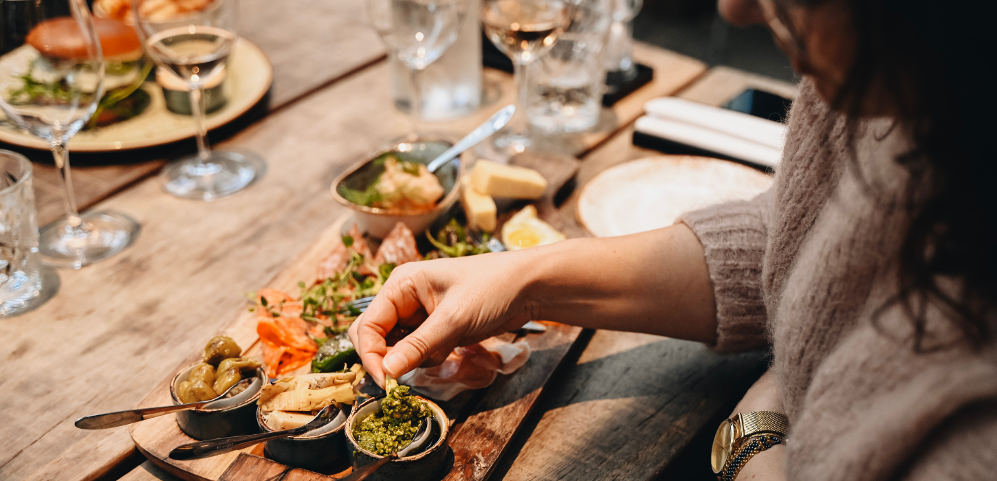 A couple enjoys tapas and a glass of wine on a romantic date in Torvehallerne