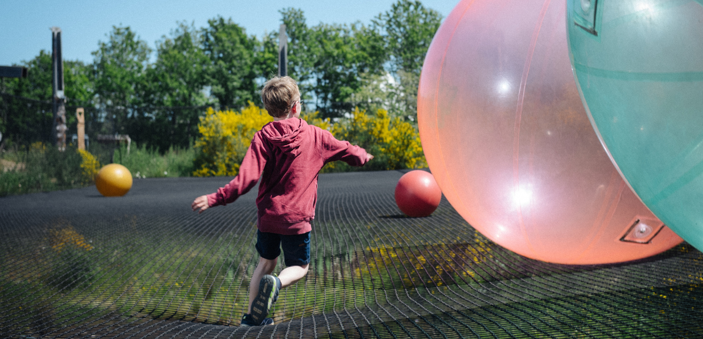 Boy jumps in WOW PARK on big trampoline with big bouncy balls
