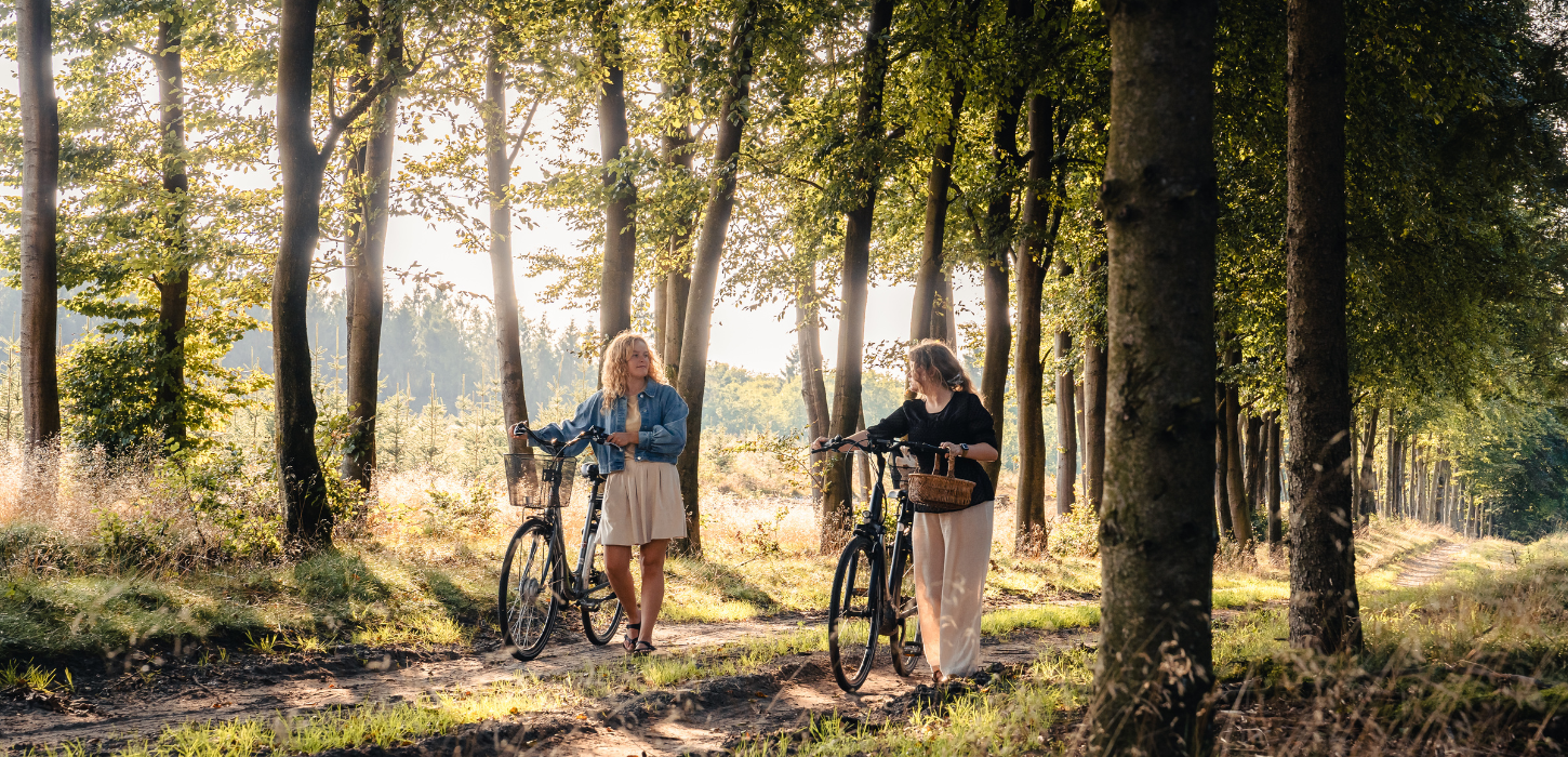 Zwei Frauen auf einer Pilztour im Wald mit Fahrrädern