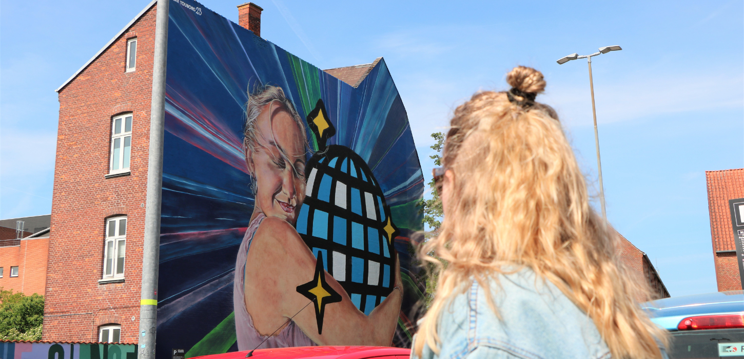 Person betrachtet Straßenkunst im Stadtzentrum von Vejle