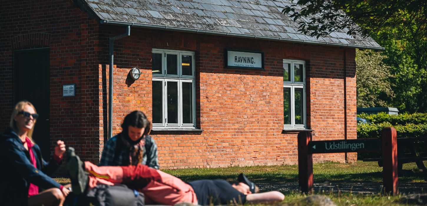 A group of hikers take a break at Ravning Station by the Ravning Bridge