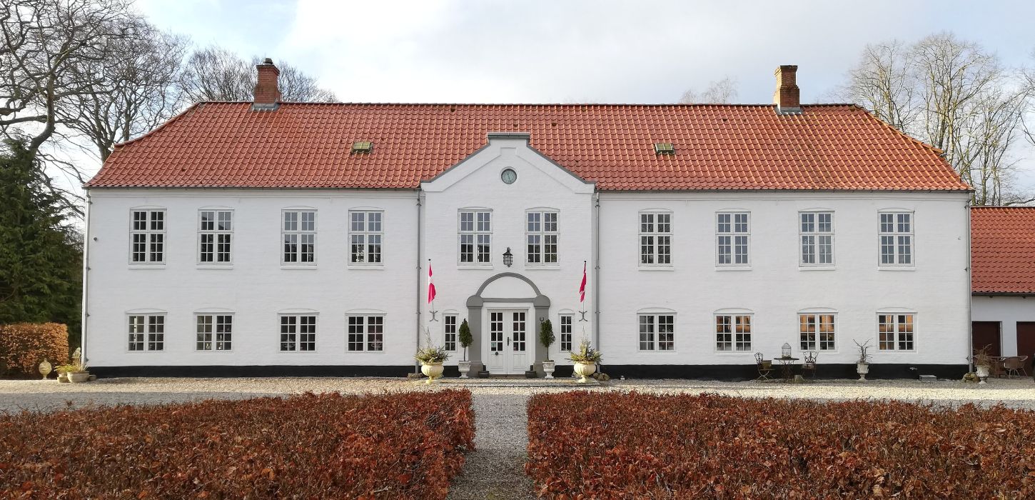 The main building of Haughus Manor seen from the courtyard on a spring day