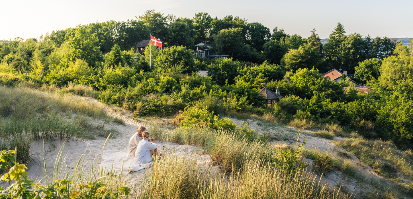 Frauen sitzen auf der Sanddüne am Hvidbjerg Strand in Vejle