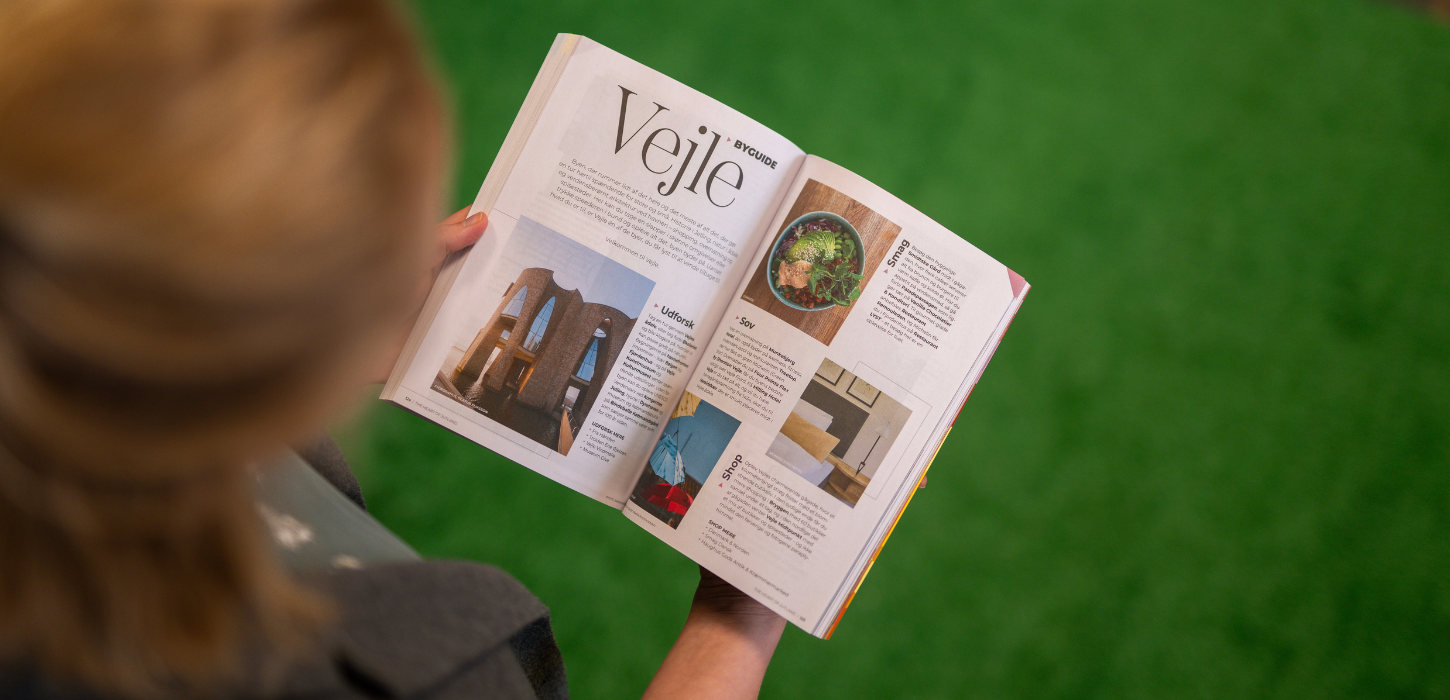 Kvinde kigger i destinationsguiden The Heart of Jutland 2026